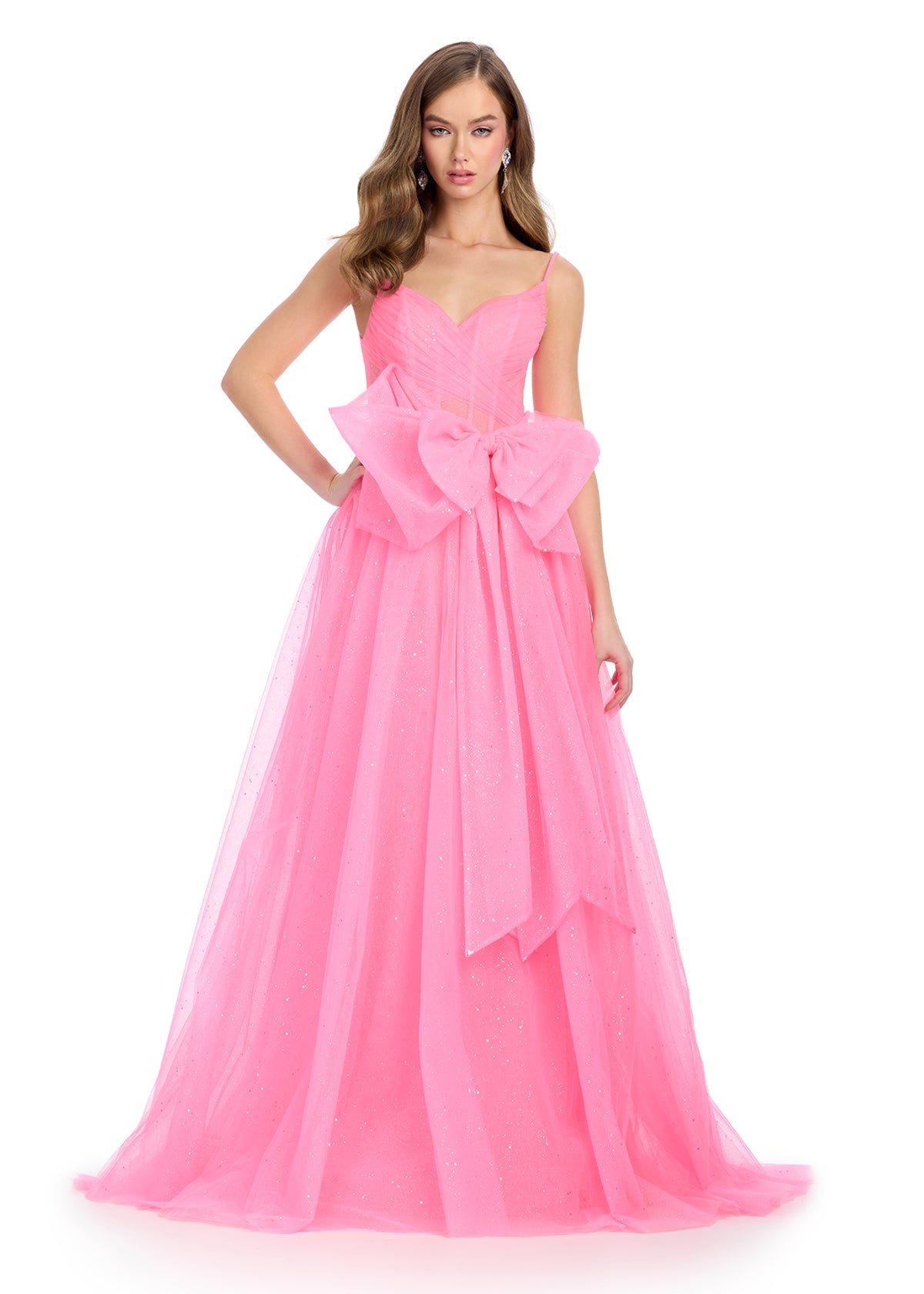 Sparkle all night in this enchanting tulle gown featuring a sweetheart neckline, delicate spaghetti straps, and a statement bow accent for a touch of elegance. Perfect for special occasions.