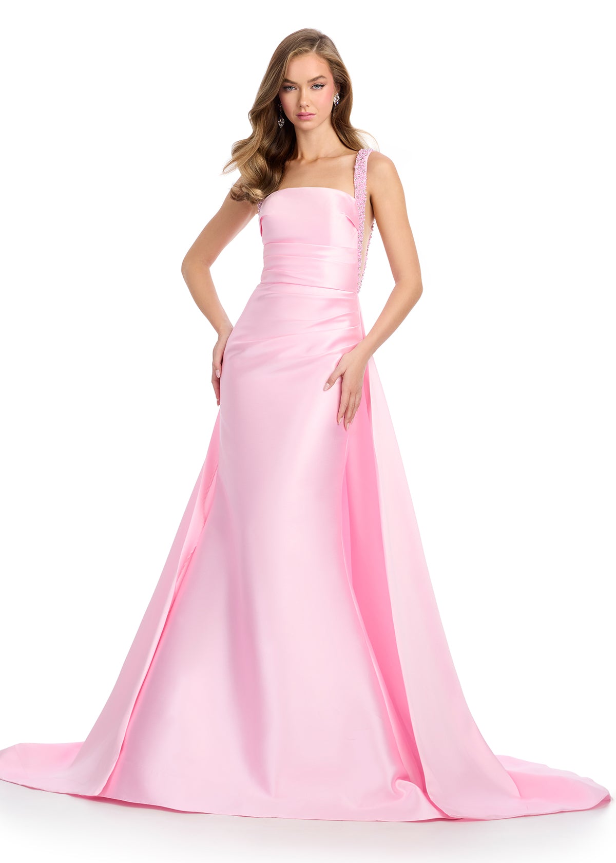  Regal mikado gown featuring fully beaded straps, a ruched bustier for a flattering fit, a sleek column skirt, and a sweeping overskirt for a dramatic, timeless look. Perfect for making a grand entrance.