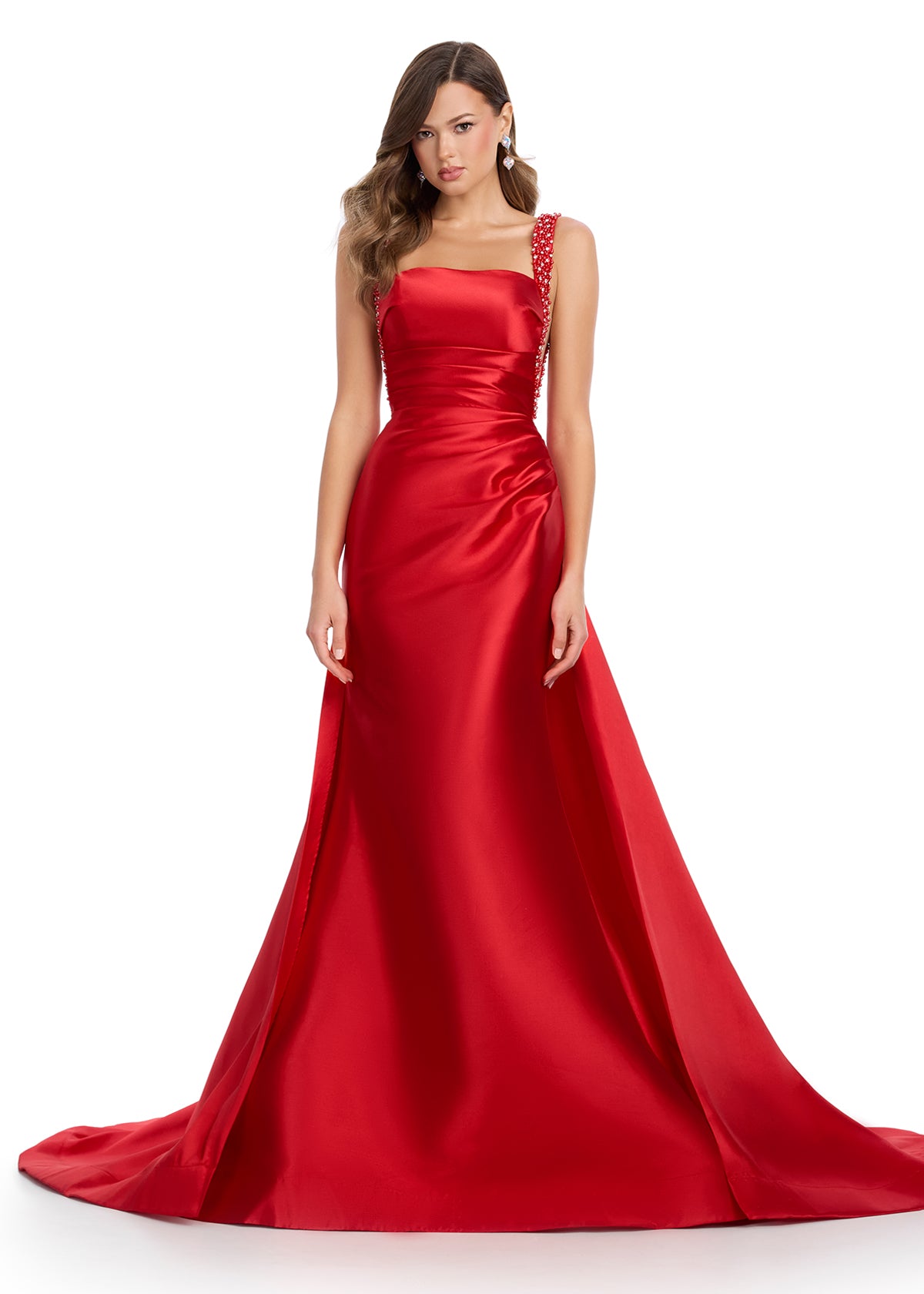 Regal mikado gown featuring fully beaded straps, a ruched bustier for a flattering fit, a sleek column skirt, and a sweeping overskirt for a dramatic, timeless look. Perfect for making a grand entrance.