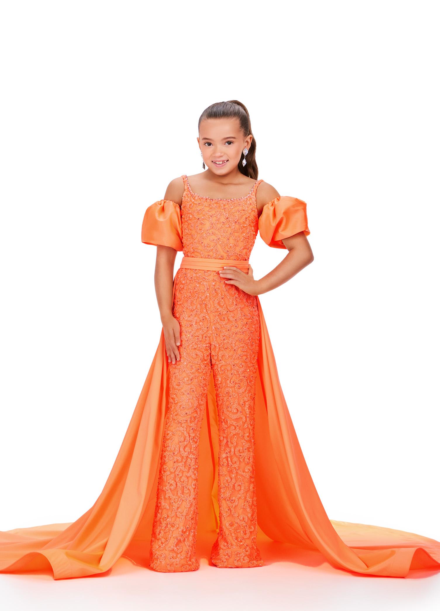 Orange ASHLEYlauren 8269 fully beaded kids jumpsuit featuring a square neckline, dramatic removable taffeta puff sleeves, and a detachable taffeta overskirt for a bold and versatile statement look.