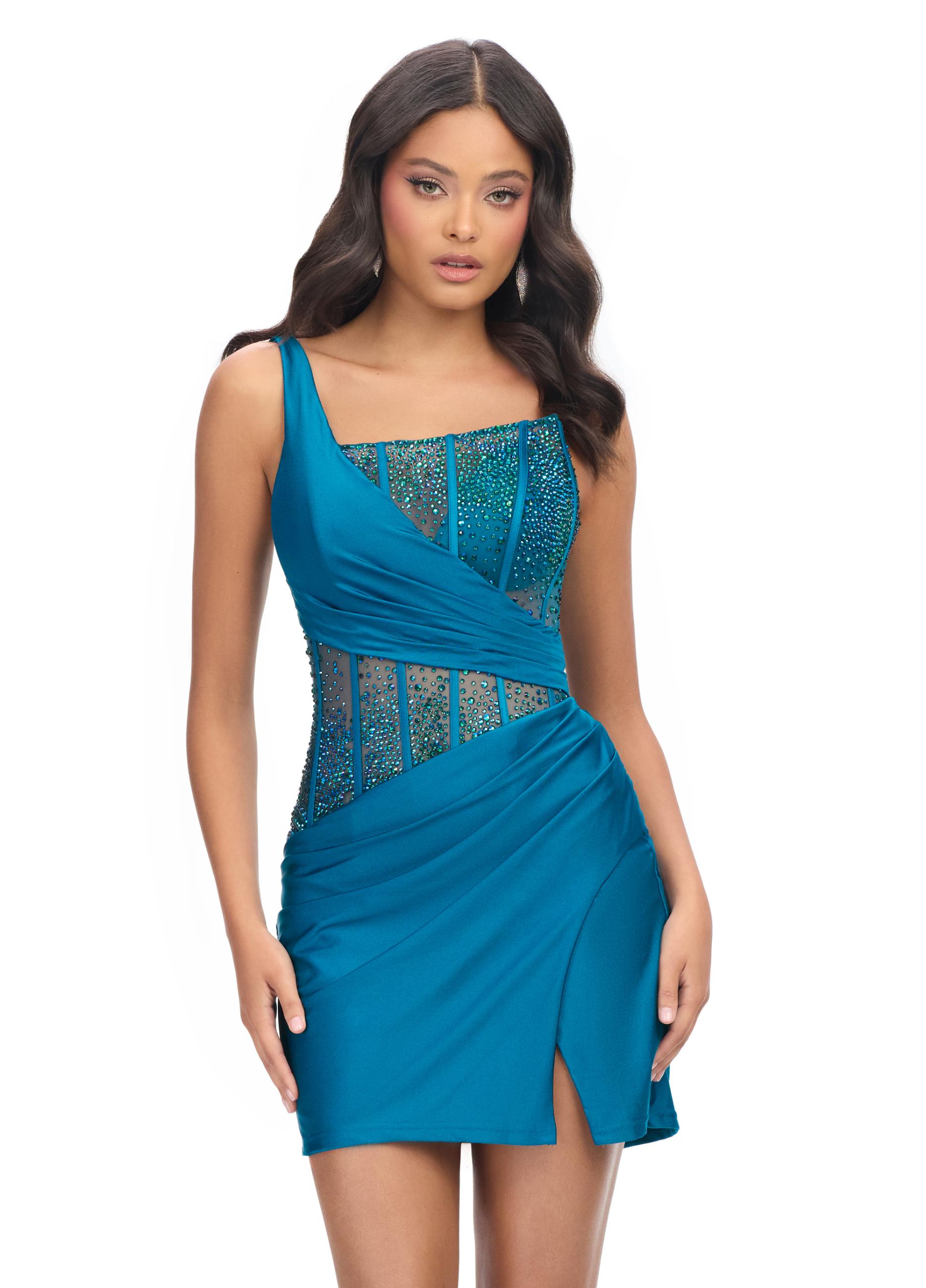 Peacock ASHLEYlauren 4691 one shoulder cocktail dress featuring a fully beaded corset bustier with press-on stones, a wrap skirt, and a left leg slit for an elegant and glamorous look.