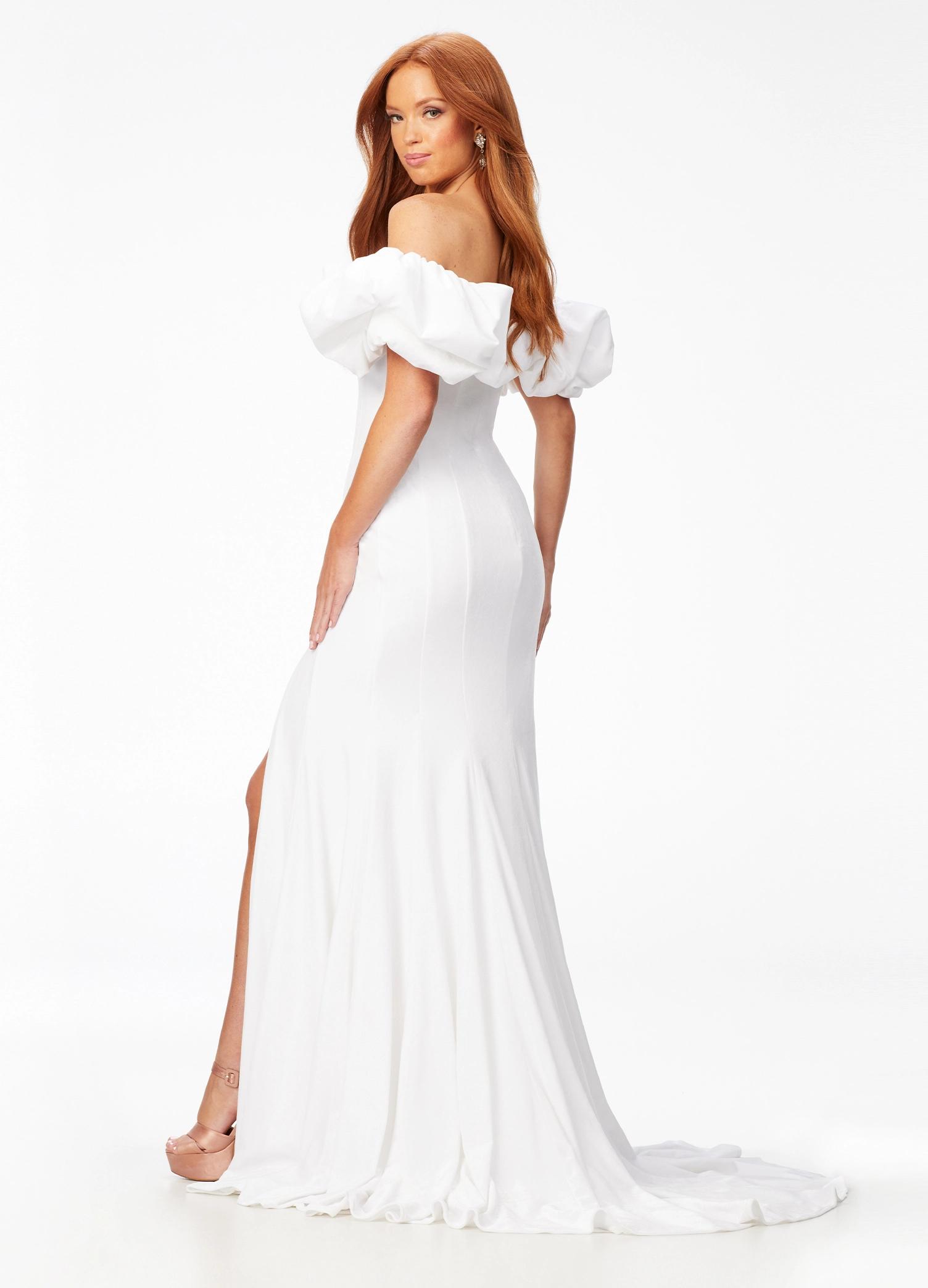 Back - White ASHLEYlauren 11217 – A magnificent off-shoulder velvet gown featuring oversized ruffle details, a contour seamed skirt with a left leg slit, and a dramatic train. Perfect for making a bold, elegant statement at any event.