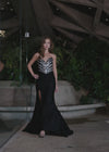 Video -  Sparkling strapless gown featuring a structured bustier adorned with press-on stones in an animal print-inspired pattern. Complete with a wrap skirt, right leg slit, and sweep train for a fierce and glamorous look. Perfect for special occasions.