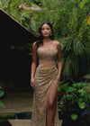 Video - Gold ASHLEYlauren 11236 jaw-dropping strapless gown featuring a fitted silhouette, corset bustier with stunning crystal beadwork, a fully beaded wrap skirt, and a left leg slit for a glamorous red carpet-worthy look.